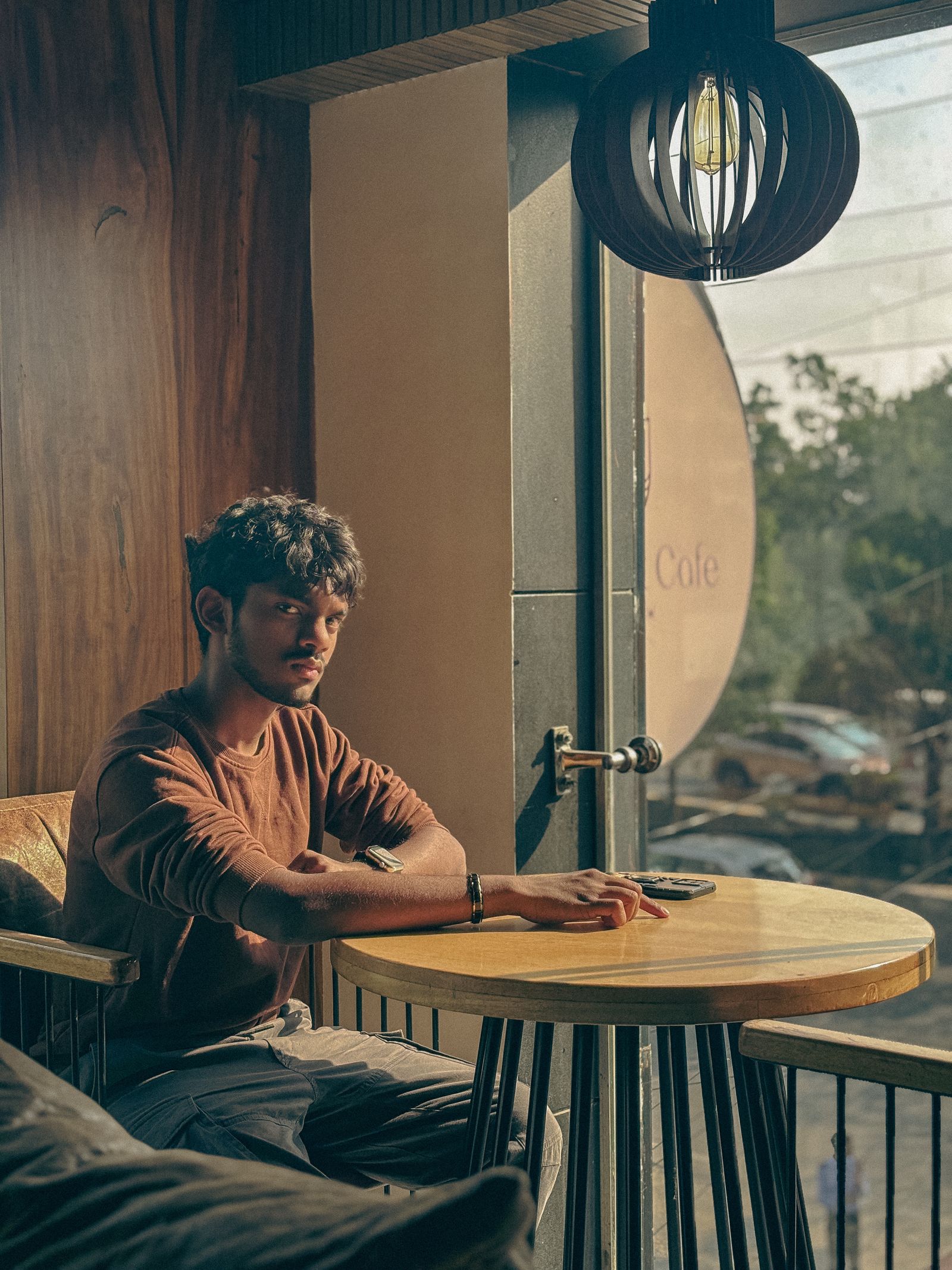 A guest at a cafe table, his phone beside his hand.